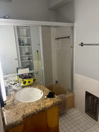 a bathroom with a granite countertop sink and a mirror