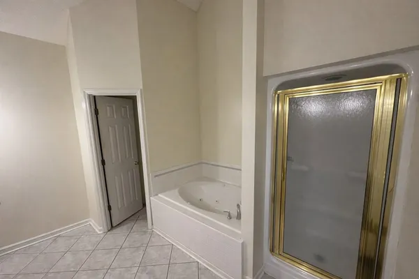 a bed sitting in a bedroom next to a lamp