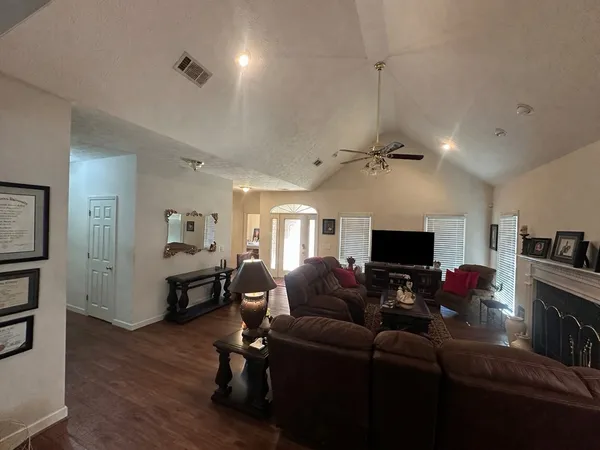 a living room with furniture a flat screen tv and a fireplace
