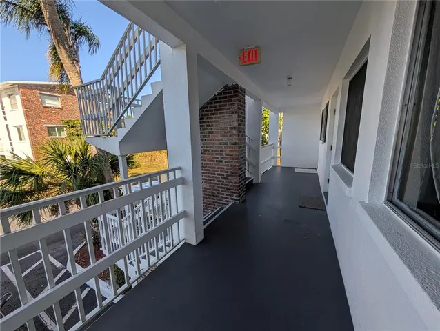 a view of staircase with railing and a window