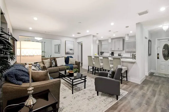 a kitchen with stainless steel appliances granite countertop a stove a sink and white cabinets