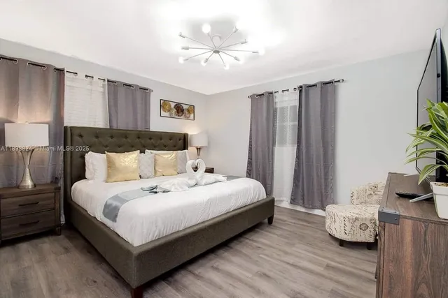 a bedroom with bed and a chandelier