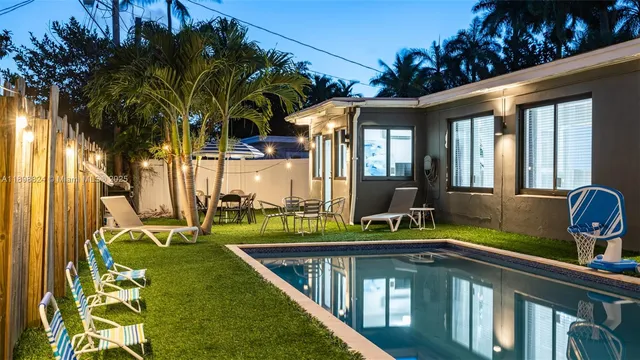 a view of a house with swimming pool and a yard