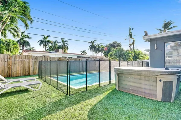 an aerial view of residential houses with yard and lake view