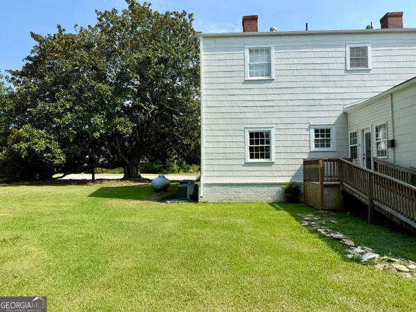 a view of a house with a yard and sitting area
