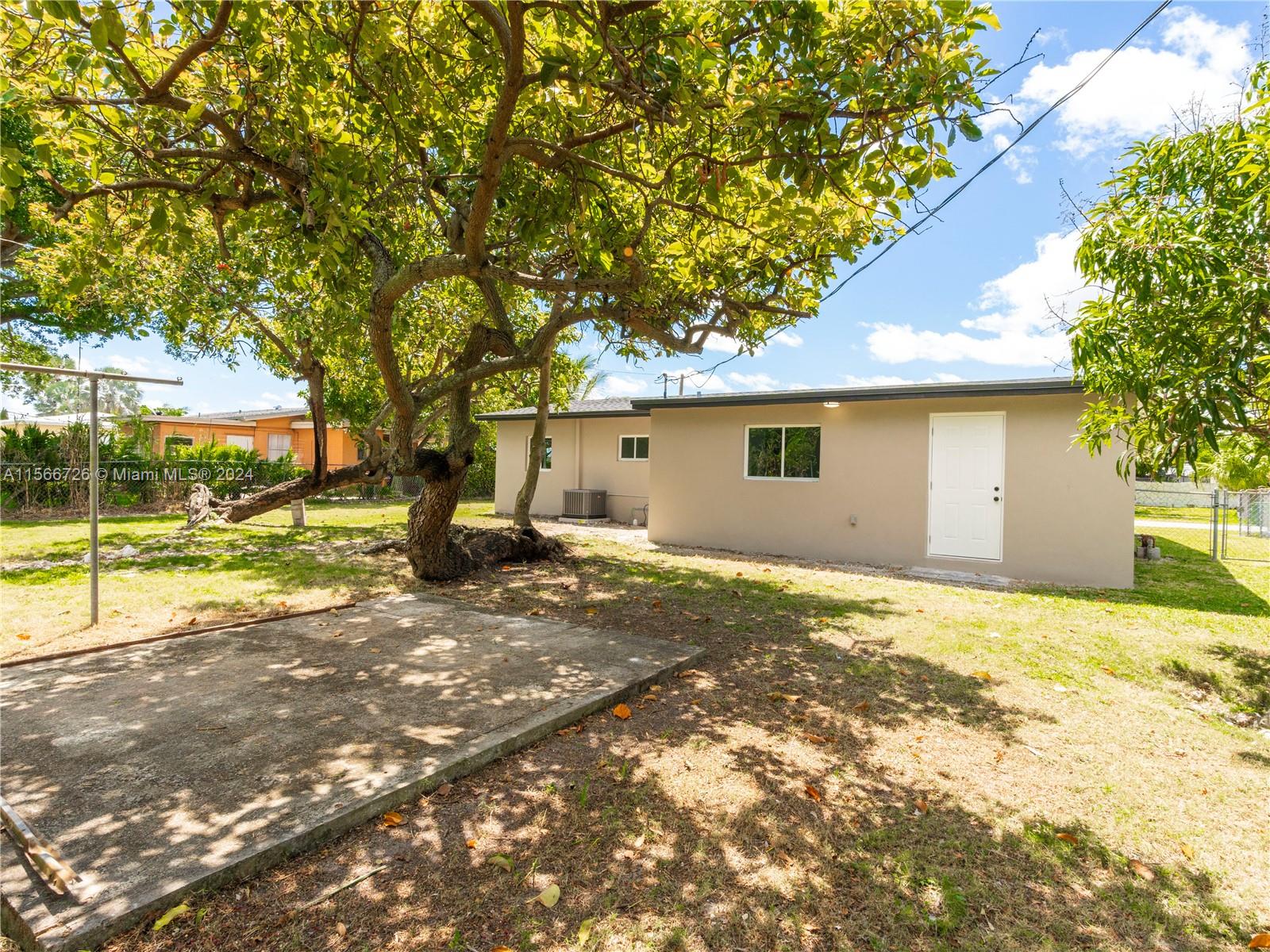 11561 Southwest 187th Street Miami, FL 33157 - Photo 29 of 35 a view of a house with backyard and a tree