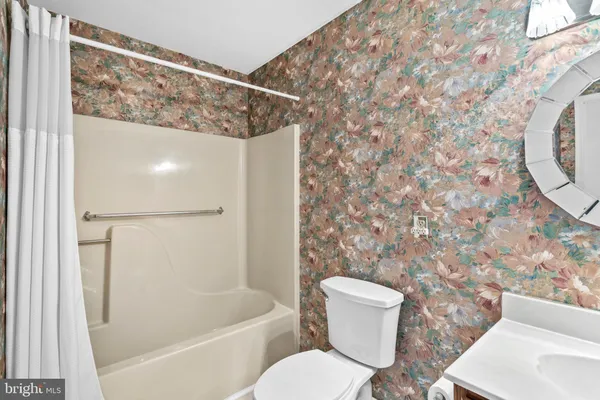 a bathroom with a toilet and a shower curtain