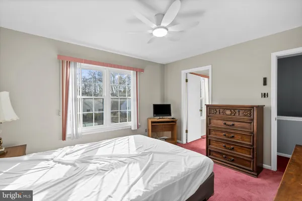 a bedroom with a bed a dresser and a flat screen tv