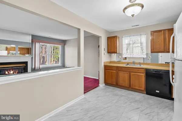 a large kitchen with a sink and dishwasher a stove top oven with wooden floor