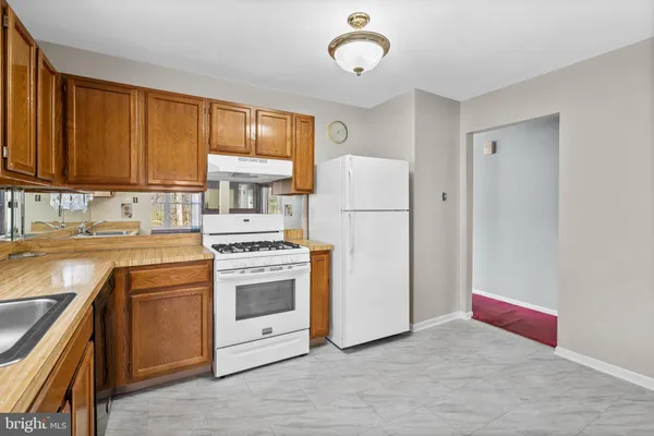 a kitchen with a stove a sink and a refrigerator