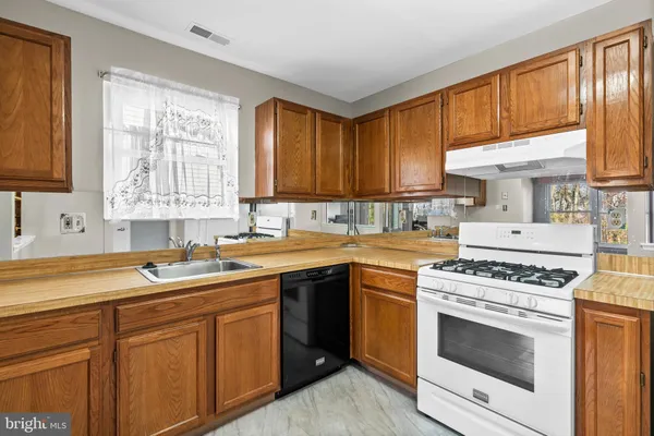 a kitchen with a sink stove top oven and cabinets