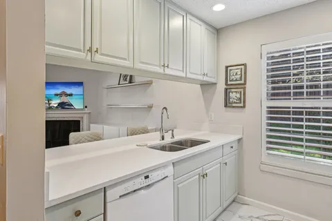 a kitchen with stainless steel appliances granite countertop a sink and dishwasher with white cabinets