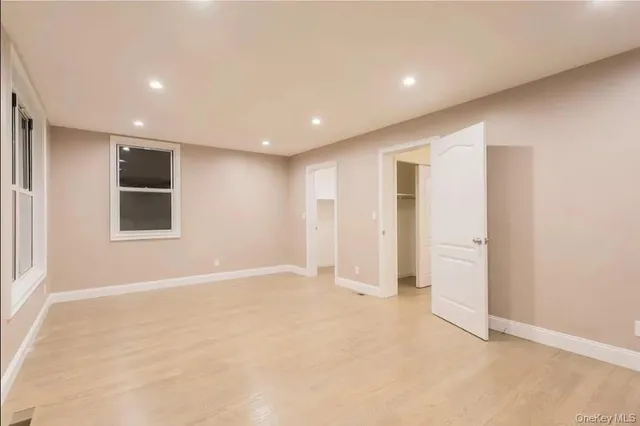 an empty room with windows and closet