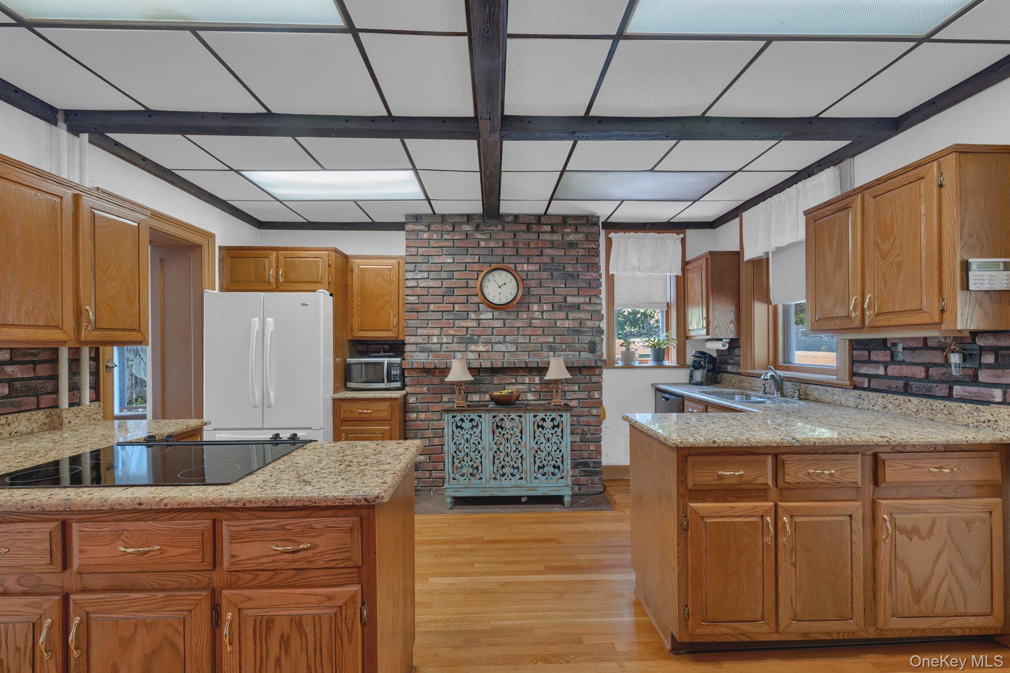470 Little Britain Road Newburgh, NY 12550 - Photo 22 of 45 Kitchen featuring a peninsula, light wood-style flooring, light stone countertops, freestanding refrigerator, and beamed ceiling