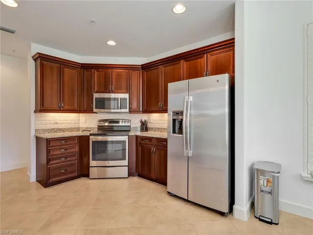 a kitchen with stainless steel appliances granite countertop a refrigerator and a stove top oven