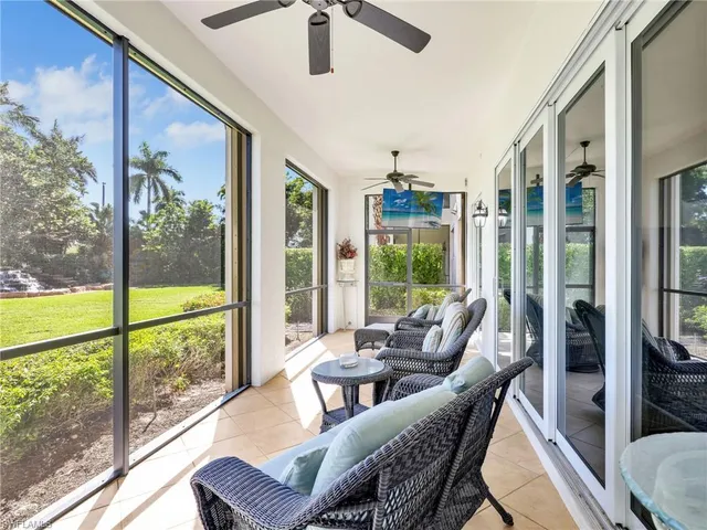 a living room with furniture and large windows