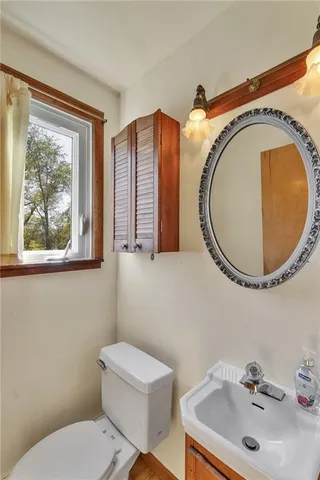 a bathroom with a toilet sink and mirror