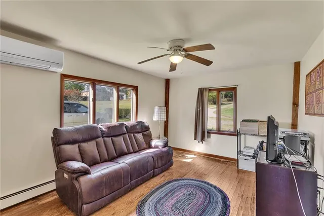 a living room with furniture ceiling fan and a wooden floor