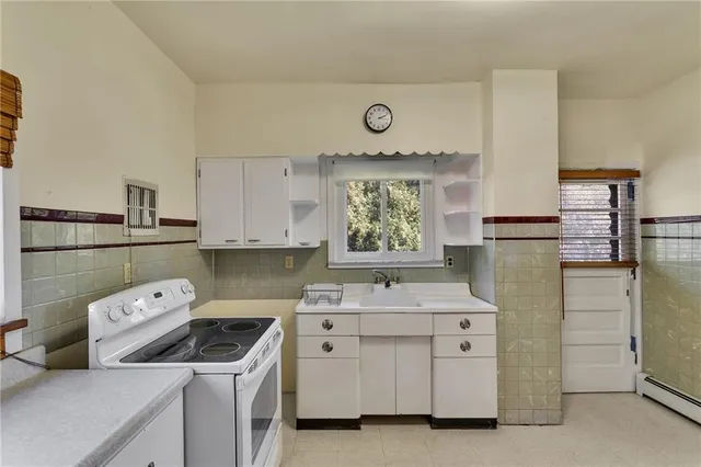 a kitchen with a stove sink and cabinets