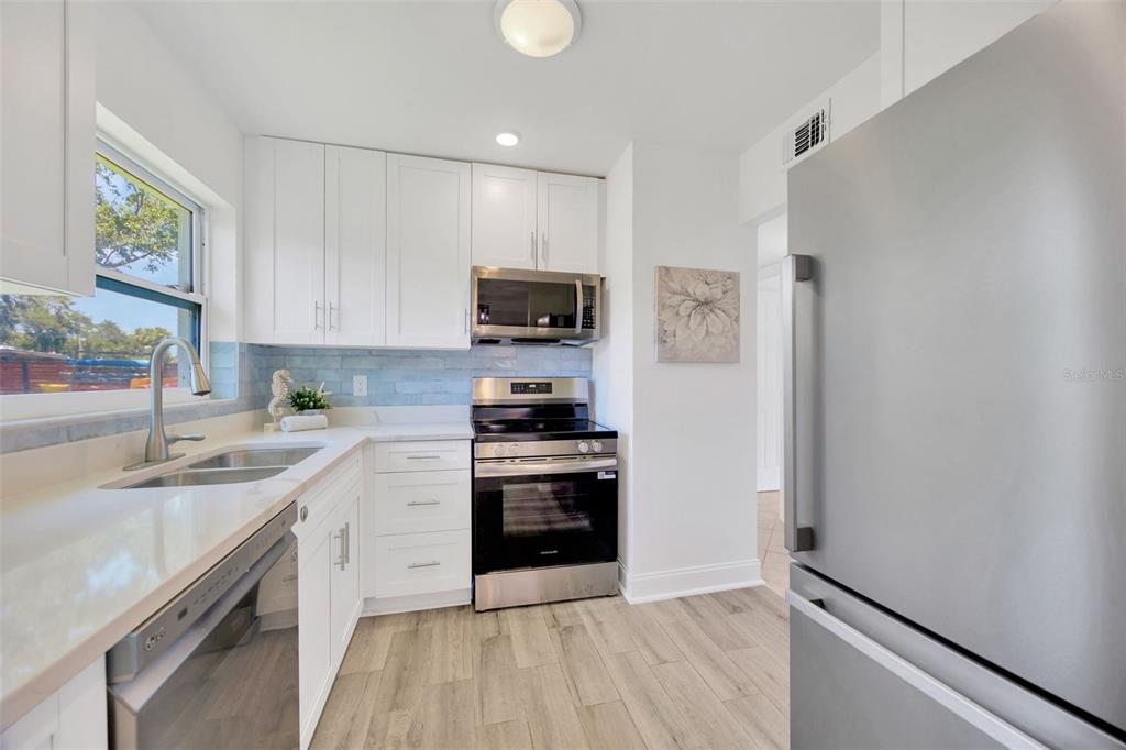 9935 River Drive Gibsonton, FL 33534 - Photo 10 of 29 a kitchen with stainless steel appliances granite countertop a stove top oven a sink and a granite counter tops