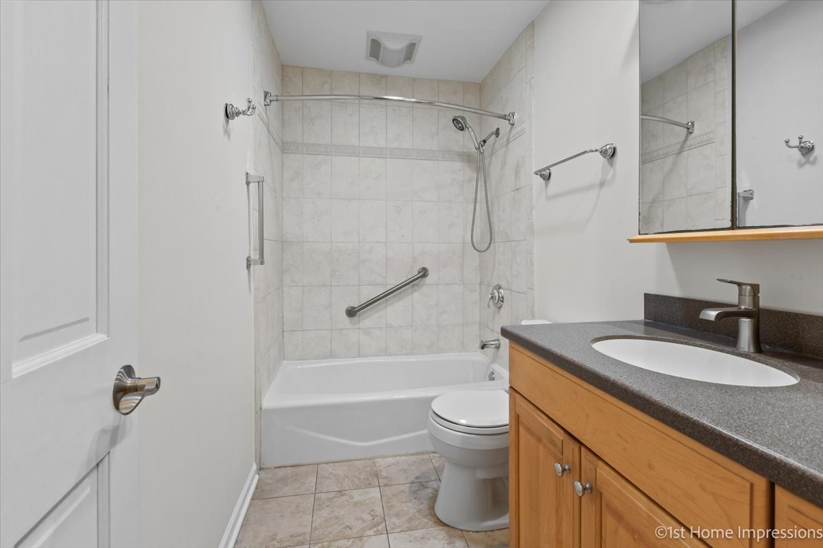 10937 Austin Avenue Chicago Ridge, IL 60415 - Photo 12 of 26 a bathroom with a granite countertop sink a toilet and a bathtub