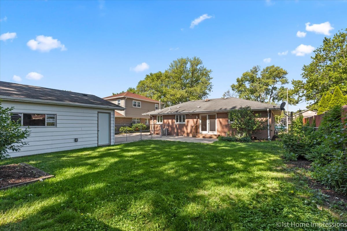 10937 Austin Avenue Chicago Ridge, IL 60415 - Photo 25 of 26 a backyard of a house with table and chairs under an umbrella