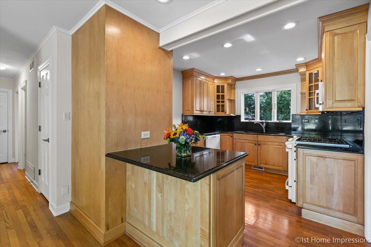10937 Austin Avenue Chicago Ridge, IL 60415 - Photo 7 of 26 a kitchen with kitchen island granite countertop a sink and white cabinets