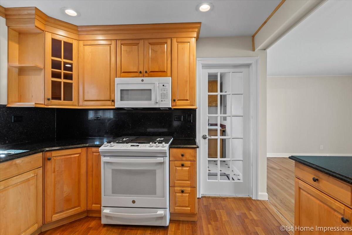 10937 Austin Avenue Chicago Ridge, IL 60415 - Photo 9 of 26 a kitchen with granite countertop a stove and a microwave oven