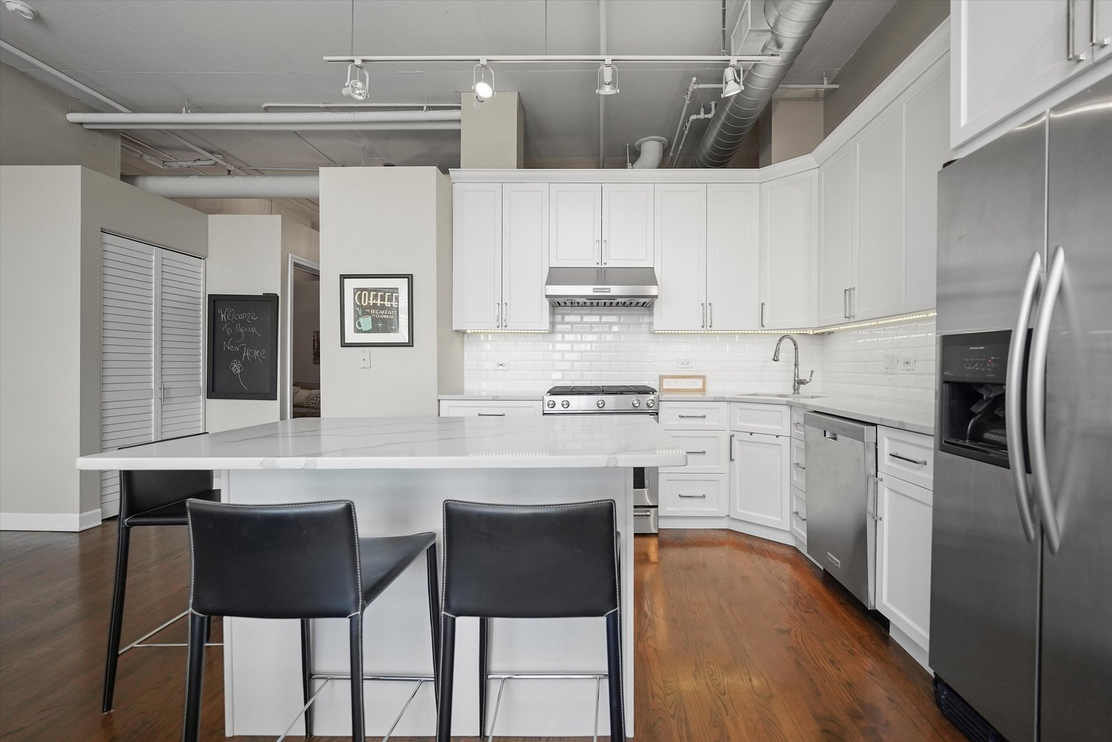1301 West Madison Street, Unit 629 Chicago, IL 60607 - Photo 3 of 25 a kitchen with stainless steel appliances a table chairs refrigerator and cabinets