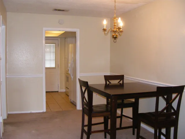 a view of a dining room with furniture and chandelier