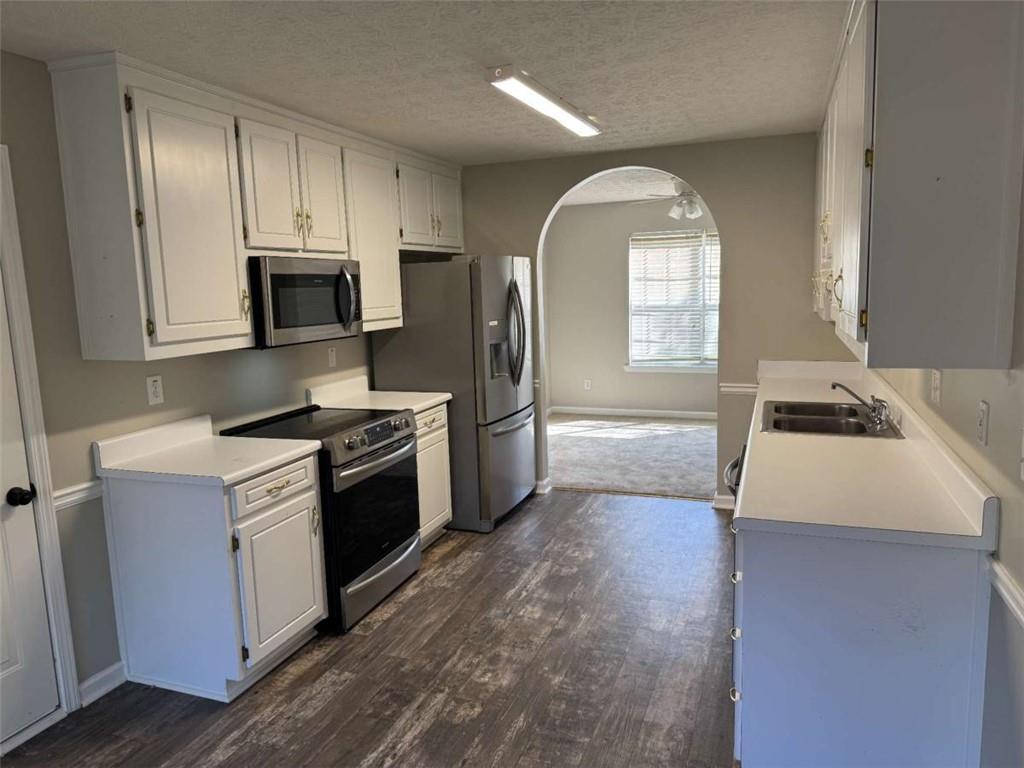 1672 Walters Park Court Loganville, GA 30052 - Photo 12 of 35 a kitchen with stainless steel appliances granite countertop a stove a sink and a microwave