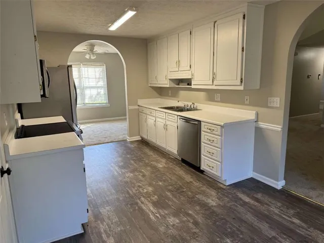 a kitchen with granite countertop a sink and a stove top oven