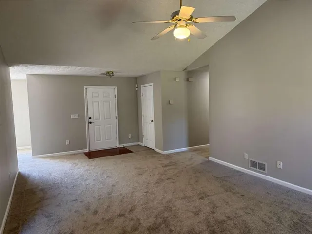 an empty room with closet and a chandelier fan
