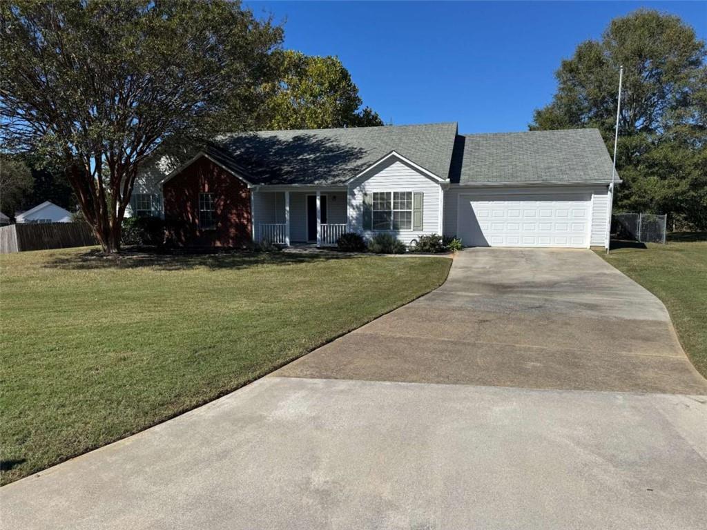 1672 Walters Park Court Loganville, GA 30052 - Photo 2 of 35 a front view of a house with a garden and trees