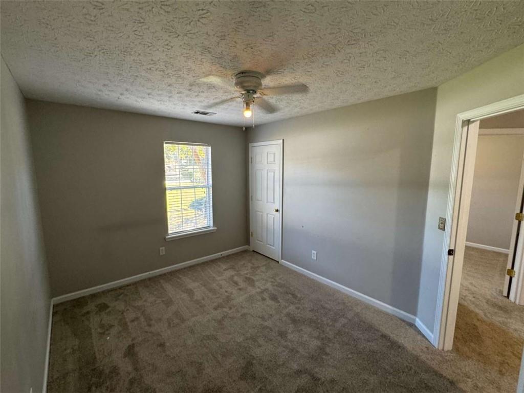 1672 Walters Park Court Loganville, GA 30052 - Photo 23 of 35 an empty room with windows and fan