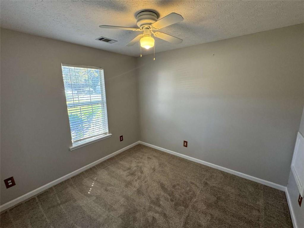 1672 Walters Park Court Loganville, GA 30052 - Photo 24 of 35 an empty room with a window and a fan