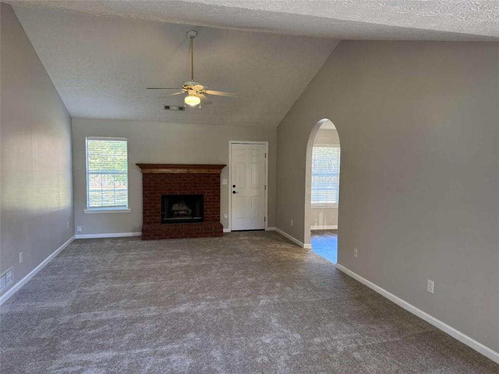 1672 Walters Park Court Loganville, GA 30052 - Photo 5 of 35 an empty room with windows and fireplace