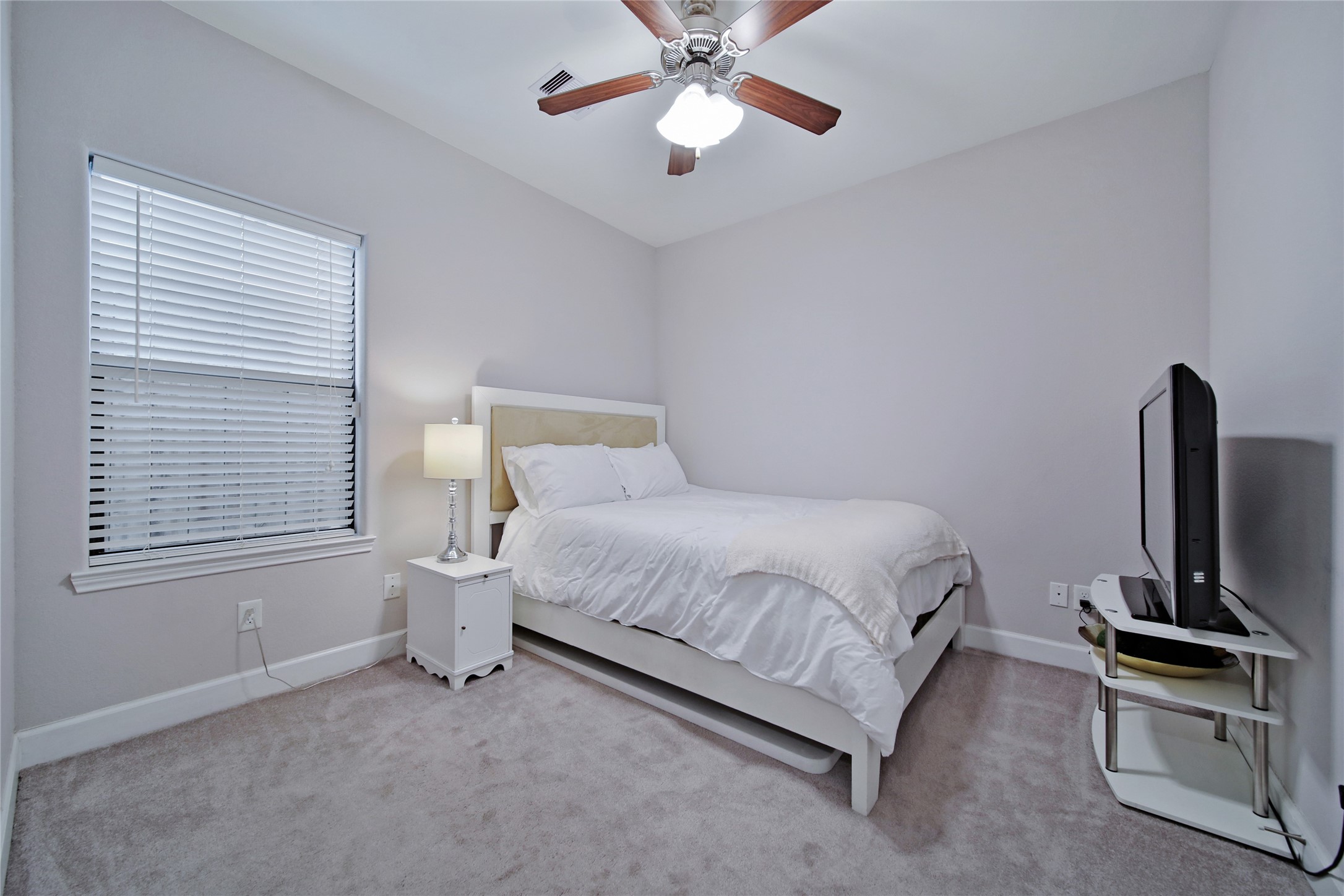 5703 Kansas Street Houston, TX 77007 - Photo 4 of 20 a bedroom with a bed and a flat tv screen on the dresser
