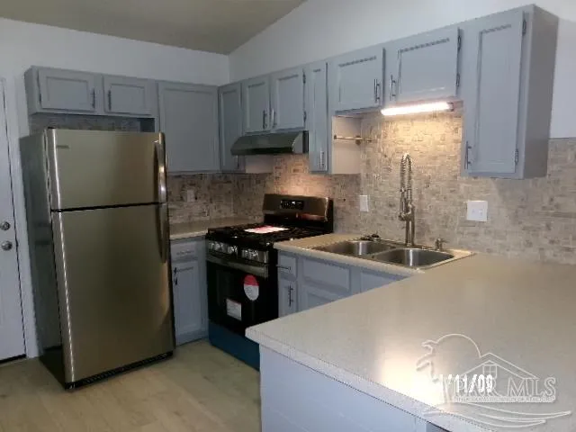 a kitchen with a refrigerator and a stove