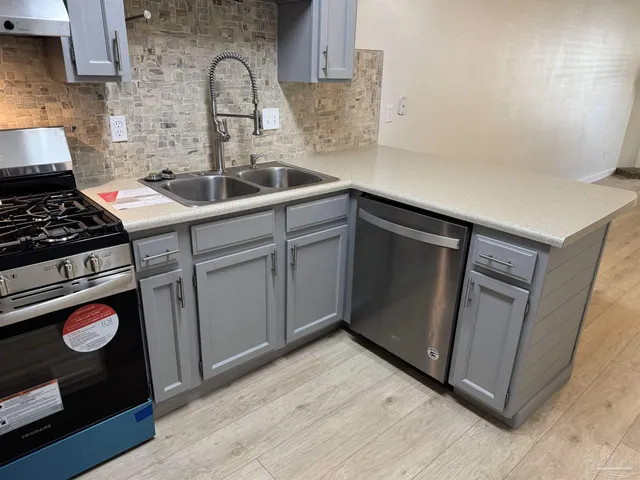 a kitchen with a sink stove and cabinets