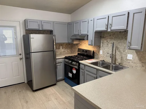 a kitchen with stainless steel appliances granite countertop a refrigerator stove a sink and dishwasher