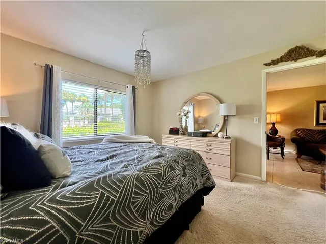 a bedroom with a bed and a dresser with mirror