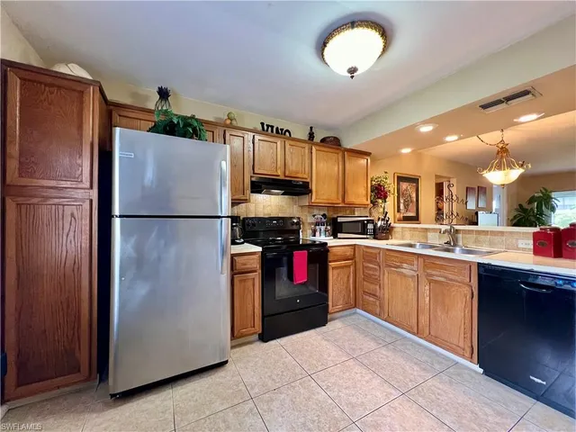 a kitchen with stainless steel appliances granite countertop a refrigerator a stove a sink and a refrigerator