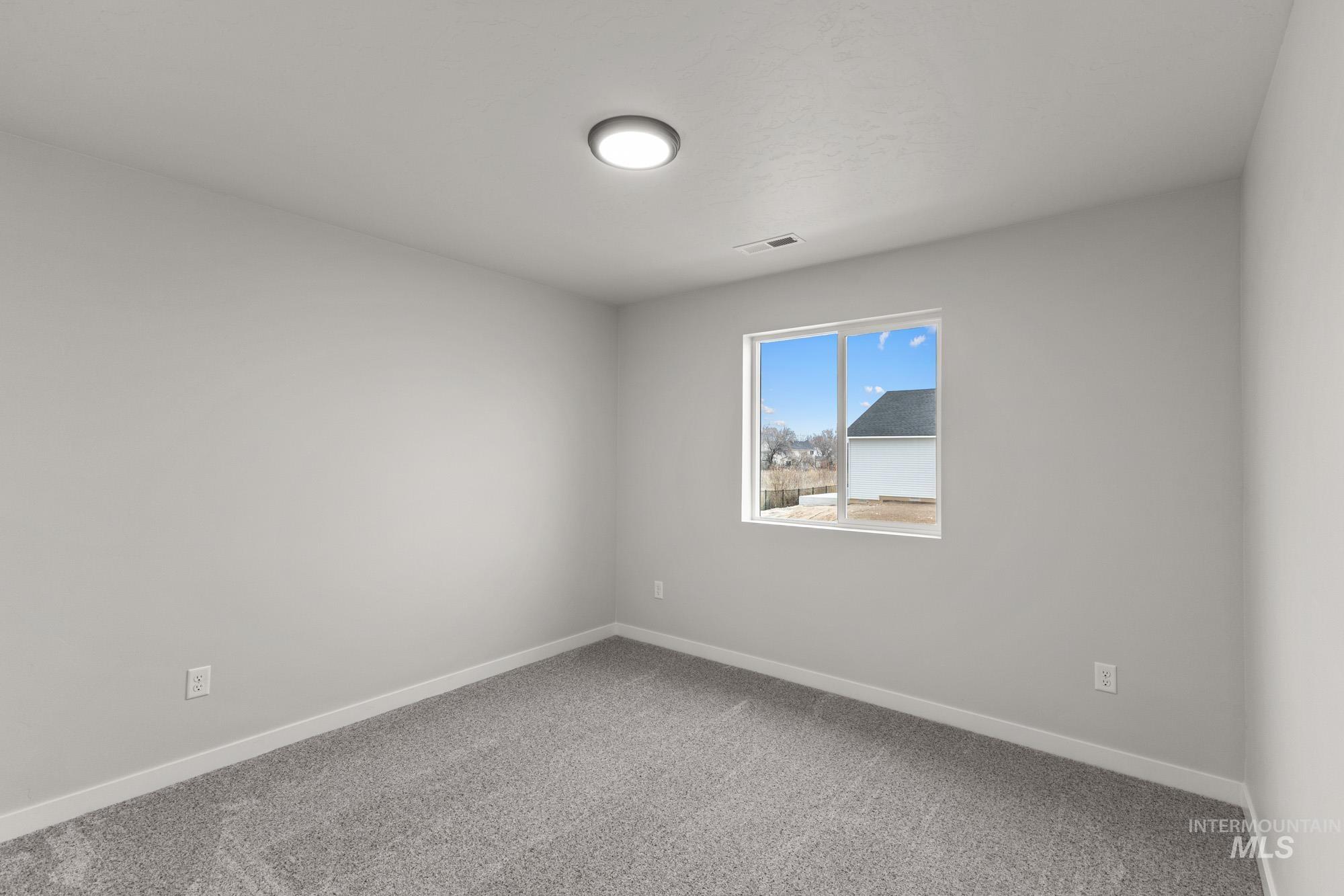 13307 Bank Street Caldwell, ID 83607 - Photo 12 of 20 Recessed ceiling light, carpeted flooring, neutral wall tones, and a window with white trim