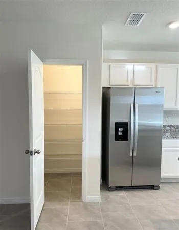 a view of a refrigerator in kitchen and a glass window