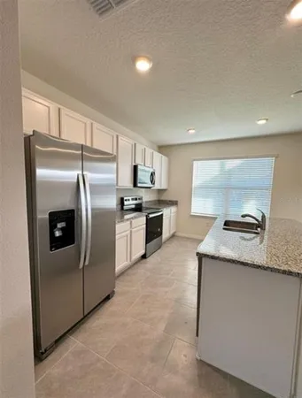 a kitchen with stainless steel appliances granite countertop a refrigerator and a stove