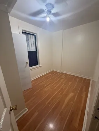 a view of a room with wooden floor and ceiling fan