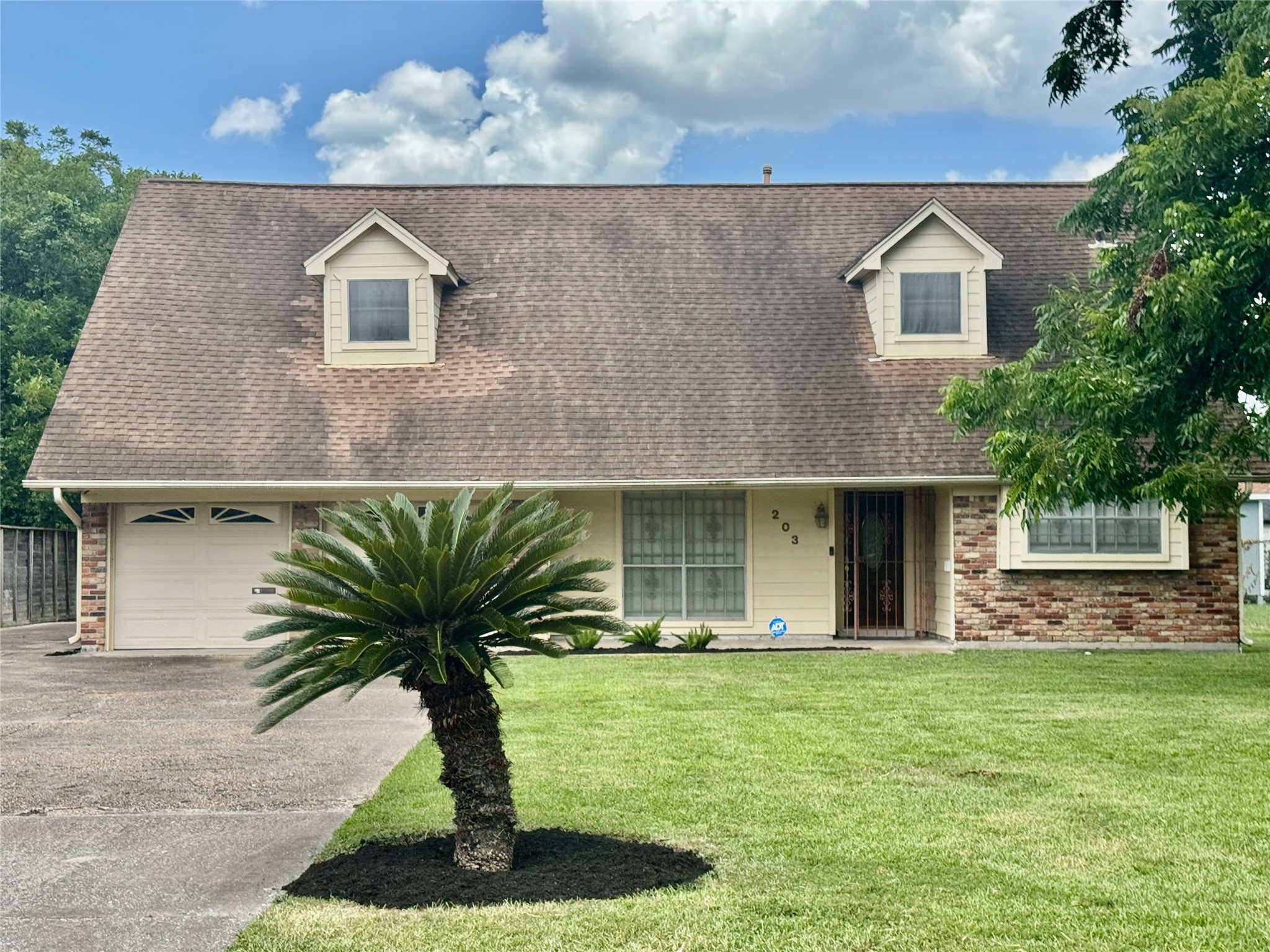 203 East Thornton Road Houston, TX 77022 - Photo 1 of 18 Charming traditional home features a classic A-frame roof with two dormer windows, a brick-and-wood exterior, and a two-car garage. Situated on nearly one-third of an acre, the property boasts a spacious front yard with a prominent tree and lush lawn, creating excellent curb appeal.