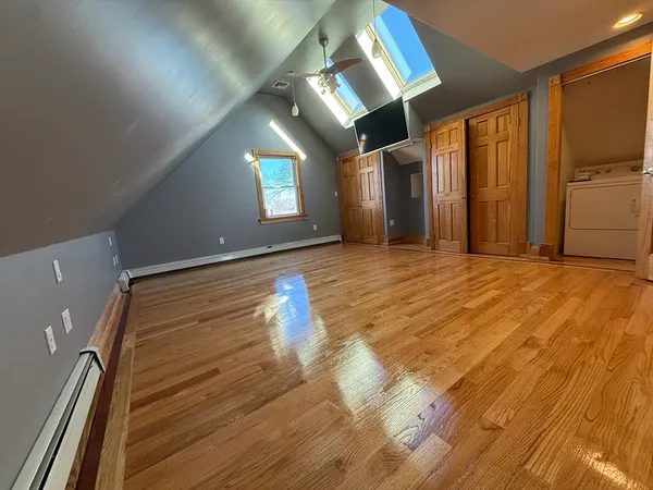 a view of empty room with wooden floor