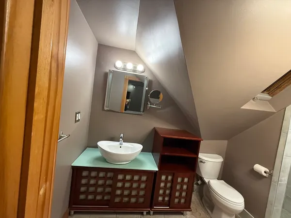 a bathroom with a sink toilet and a mirror